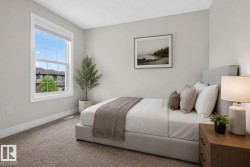 Spacious bedroom featuring light neutral wall paint, white trim, and plush carpet flooring - 
