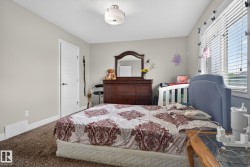 Light-colored walls with trim, brown carpet flooring, and a window with horizontal blinds - 