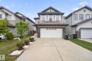 Contemporary two-story residence featuring a dual-tone facade, attached front-facing garage, concrete driveway, and landscaped front yard with decorative white stone accents - 3350 18B Street, Edmonton, AB 