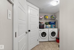 Dedicated laundry area featuring tile flooring, a built-in wire shelf, and a ceiling-mounted light fixture - 