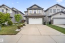 Two-story residence featuring a neutral-toned facade with stone accents and white window shutters - 3350 18B Street, Edmonton, AB 