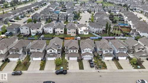 Aerial perspective of a developed residential area featuring multiple detached homes with asphalt shingle roofs and integrated garages - 3350 18B Street, Edmonton, AB 