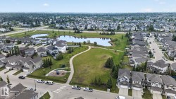 Aerial perspective showcasing a residential community with a large central park area featuring two ponds - 