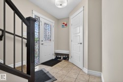 Entryway featuring a white paneled door with decorative glass inserts - 