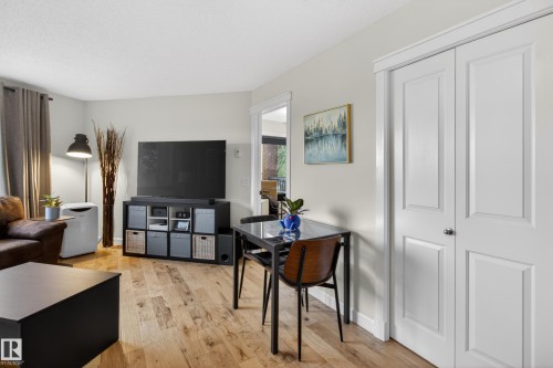 Open-concept living area with light-toned walls and wood-finish flooring - 211 3719 Whitelaw Lane, Edmonton, AB 