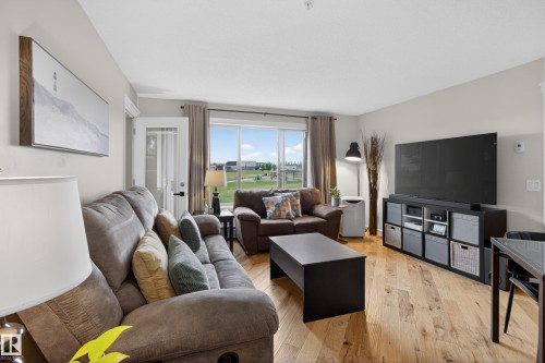 Living area featuring light wood-finish flooring and a neutral color palette - 211 3719 Whitelaw Lane, Edmonton, AB 