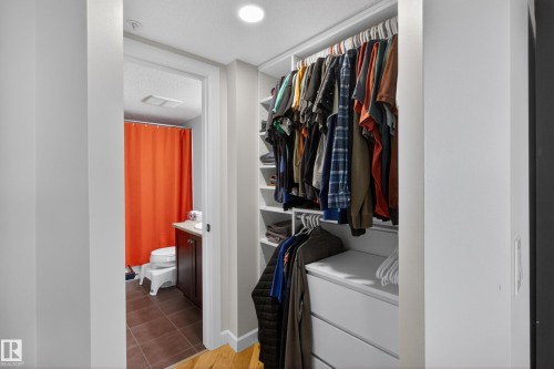 Built-in closet organization system featuring multiple hanging rods, shelving, and drawer storage - 211 3719 Whitelaw Lane, Edmonton, AB 