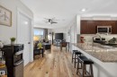 Open-concept living area featuring wood-finish flooring throughout - 211 3719 Whitelaw Lane, Edmonton, AB 