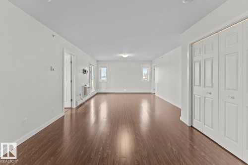 Spacious room featuring wood-finish flooring, white walls, and a recessed ceiling light - 1302-1601 8 Avenue, Cold Lake, AB 
