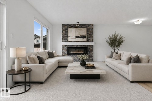 Living area featuring a stone-clad fireplace with a white mantel and an electric insert, large windows, light-toned carpeting, and light-toned wall finishes - 3806 Powell Wynd, Edmonton, AB 