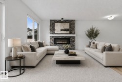 Living area featuring a stone-clad fireplace with a white mantel and an electric insert, large windows, light-toned carpeting, and light-toned wall finishes - 