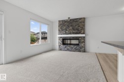 Living space featuring a stacked stone fireplace with a contemporary linear insert and a white mantel - 