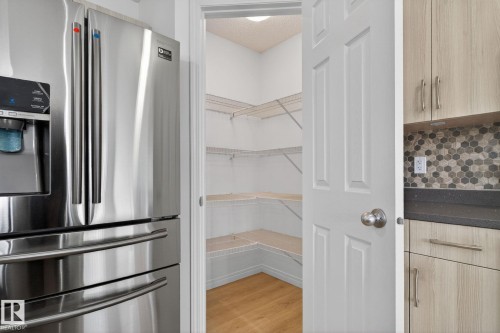 Walk-in pantry with white wire shelving and wood-finish flooring - 3806 Powell Wynd, Edmonton, AB 