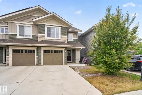 Contemporary multi-story residence featuring a two-car garage with carriage-style doors, multi-tone horizontal siding, and a gabled roofline - 3806 Powell Wynd, Edmonton, AB 