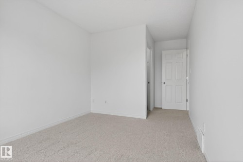 Neutral-toned carpeted flooring complements white walls and trim - 3806 Powell Wynd, Edmonton, AB 