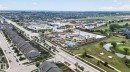 Aerial overview showcasing a developed residential area with row homes, commercial properties, and a golf course - 3806 Powell Wynd, Edmonton, AB 
