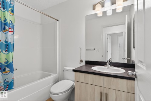 Full bathroom featuring a tub-shower combination, a toilet, and a vanity with a dark countertop - 3806 Powell Wynd, Edmonton, AB 