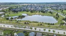 Expansive aerial perspective showcasing a residential community centered around a large central lake - 3806 Powell Wynd, Edmonton, AB 