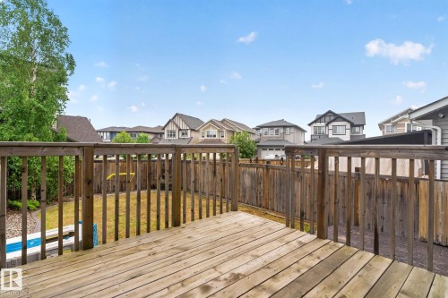 Outdoor wood deck with railing overlooking a fenced backyard - 3806 Powell Wynd, Edmonton, AB 