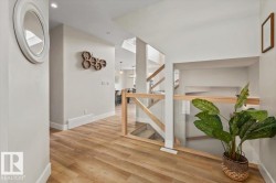 Hallway featuring wood-finish flooring, recessed lighting, and a contemporary glass and wood railing system - 