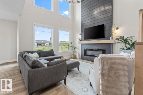 Living space featuring a soaring vaulted ceiling and abundant natural light from multiple large windows - 45 Elwyck Gate, Spruce Grove, AB 