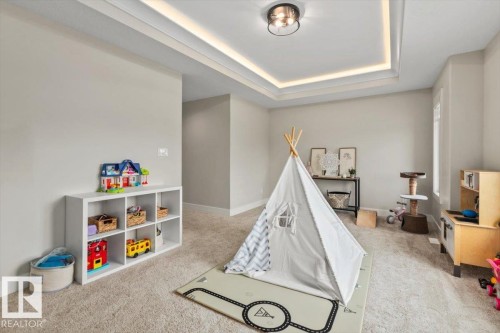 Carpeted room with tray ceiling featuring recessed lighting and a flush-mount fixture - 45 Elwyck Gate, Spruce Grove, AB 