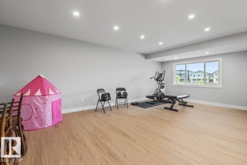 Spacious interior room featuring light wood-finish flooring and multiple recessed ceiling lights - 45 Elwyck Gate, Spruce Grove, AB 