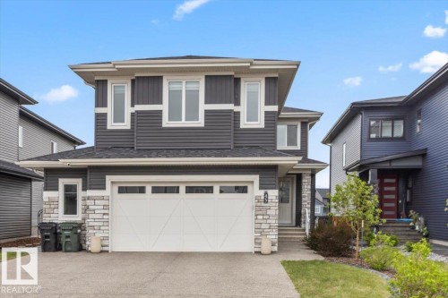 Contemporary two-story exterior with dark gray siding, white trim, and a prominent attached two-car garage - 45 Elwyck Gate, Spruce Grove, AB 