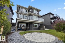 Contemporary multi-level residence featuring dark horizontal siding and prominent white trim - 