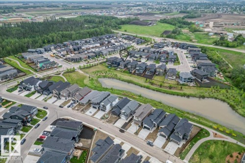 Aerial view of a residential neighborhood featuring detached homes with dark roofs, paved streets, and concrete driveways - 45 Elwyck Gate, Spruce Grove, AB 