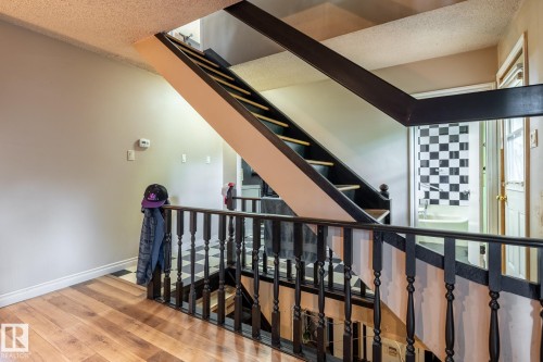 Two-story staircase with dark wood balusters and handrails - 5919 121 Avenue, Edmonton, AB 