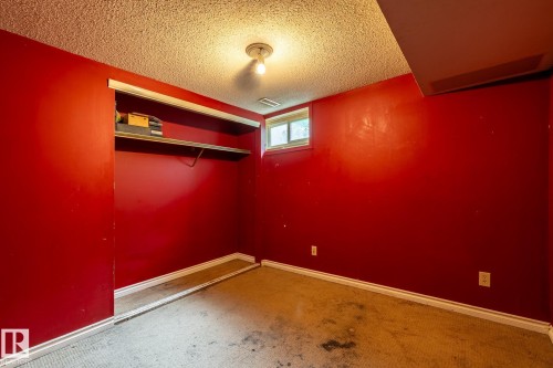 Finished room with vibrant red walls, white trim, and a textured ceiling - 5919 121 Avenue, Edmonton, AB 