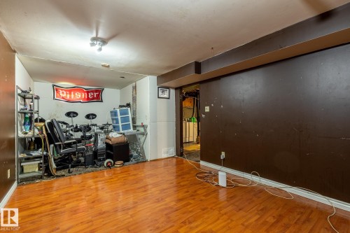 Wood-finish flooring throughout a versatile interior space featuring recessed lighting and a ceiling-mounted light fixture - 5919 121 Avenue, Edmonton, AB 
