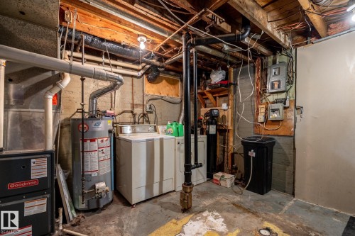 Utility area featuring exposed wood ceiling joists and concrete walls - 5919 121 Avenue, Edmonton, AB 