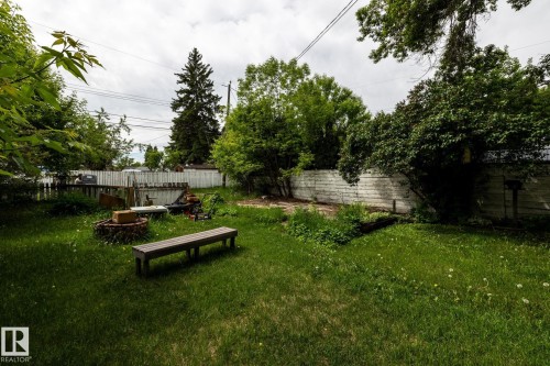 Expansive backyard featuring a lush green lawn, mature trees, and a perimeter fence - 5919 121 Avenue, Edmonton, AB 