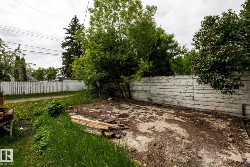 Expansive concrete pad bordered by a horizontal plank fence - 5919 121 Avenue, Edmonton, AB 