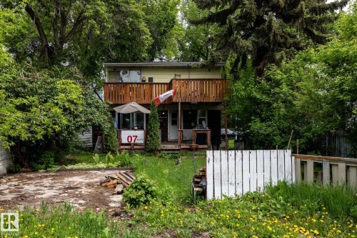 Two-story residence featuring a second-level wood-railed balcony and a ground-level covered porch - 5919 121 Avenue, Edmonton, AB 