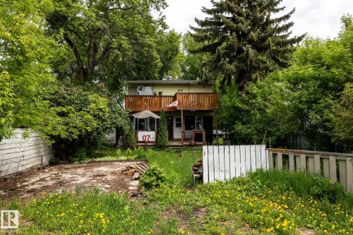Property exterior with a second-story wooden balcony and a ground-level covered porch - 5919 121 Avenue, Edmonton, AB 