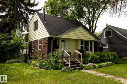 Two-story residence featuring a black shingled roof and light yellow siding - 5919 121 Avenue, Edmonton, AB 