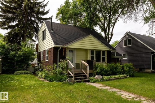 Charming exterior with light yellow siding and brown shake accents - 5919 121 Avenue, Edmonton, AB 