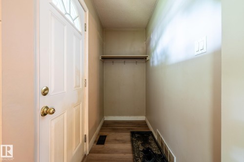 Entryway with a white paneled door featuring a decorative glass insert and brass hardware - 5919 121 Avenue, Edmonton, AB 