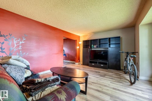 Living area featuring light wood-finish flooring and a textured ceiling - 5919 121 Avenue, Edmonton, AB 