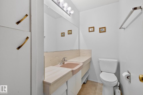 Vanity with integrated basin, polished chrome faucet, and expansive wall mirror - 9243 74 Street, Edmonton, AB 