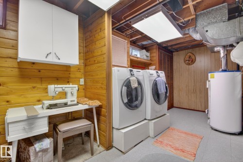 Utility area featuring wood plank walls and a drop-tile ceiling - 9243 74 Street, Edmonton, AB 
