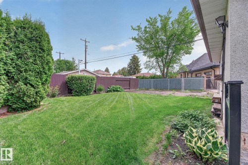 Spacious backyard featuring a manicured lawn, established perimeter shrubbery, and a partial privacy fence - 9243 74 Street, Edmonton, AB 