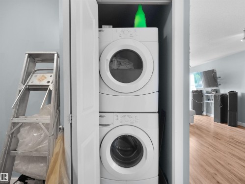 Dedicated laundry closet featuring a stackable washer and dryer unit - 406 11820 22 Avenue, Edmonton, AB 