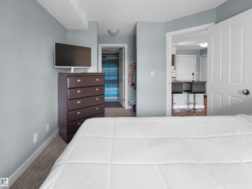 Bedroom featuring light blue walls, gray carpeting, and white trim - 406 11820 22 Avenue, Edmonton, AB 