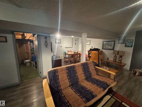 Interior space featuring wood-finish flooring, light grey walls, and a recessed ceiling - 4502 55 Avenue, Vegreville, AB 