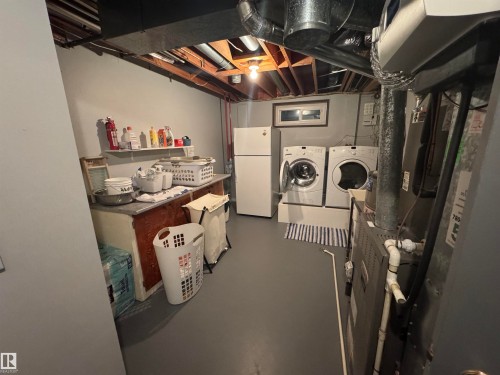 Utility space featuring a washer, dryer, and refrigerator - 4502 55 Avenue, Vegreville, AB 
