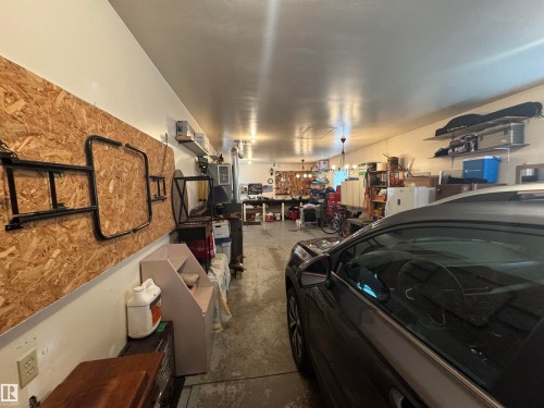 Spacious garage featuring white painted walls and a concrete floor - 4502 55 Avenue, Vegreville, AB 